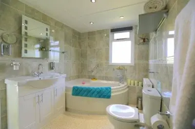 a bathroom with a tub and a sink and a toilet at Pheasant Suites in Colchester