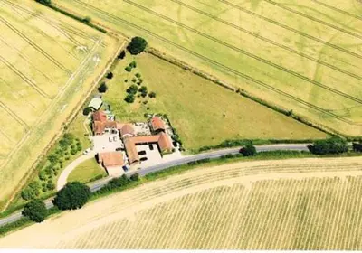 a house in the middle of a field with a road at Pheasant Suites in Colchester