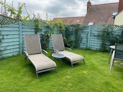 two chairs and a table in a yard with a fence at Pheasant Suites in Colchester
