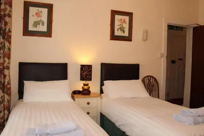 a bedroom with two beds and a nightstand between them at Lantern House in Cambridge