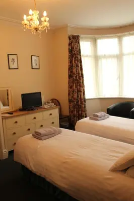 a bedroom with two beds and a desk with a laptop at Lantern House in Cambridge