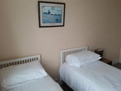 two beds in a bedroom with a picture on the wall at Lantern House in Cambridge