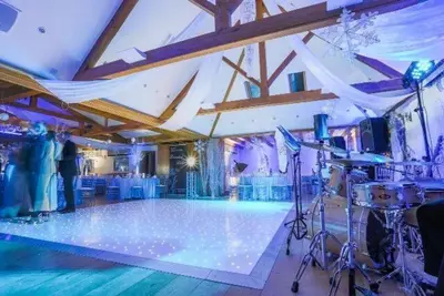 a large room with a dance floor with a stage at Mulberry House in Ongar