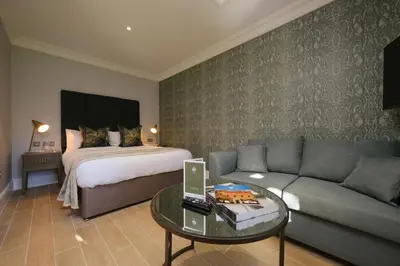 a living room with a couch and a bed at Mulberry House in Ongar