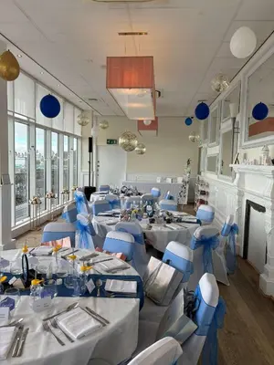 a banquet hall with white tables and blue chairs at The Palace Hotel in Southend-on-Sea