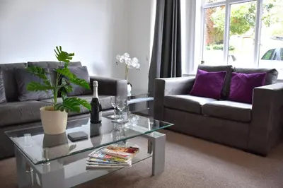 a living room with two couches and a glass table at Friarscroft Lodge Holiday Home in Wymondham