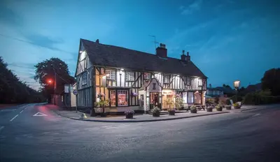 an old building with lights on a street at The Bell Inn in Newmarket