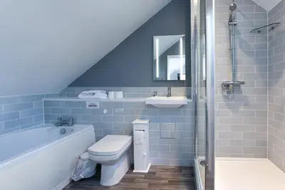 a bathroom with a toilet and a tub and a sink at The Bell Inn in Newmarket