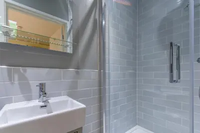 a white bathroom with a sink and a mirror at The Bell Inn in Newmarket
