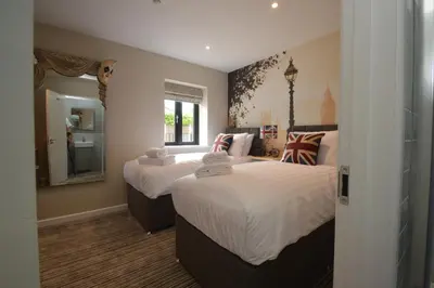 a bedroom with two beds and a mirror at The Bell Inn in Newmarket