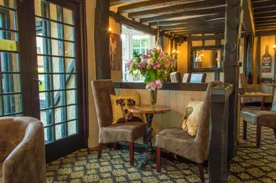 a room with chairs and a table with a vase of flowers at The Bell Inn in Newmarket