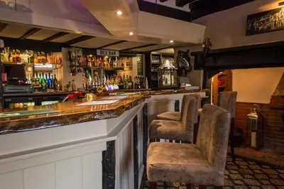 a bar with two chairs sitting at a counter at The Bell Inn in Newmarket