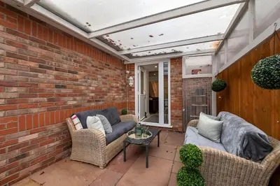 a patio with two couches and a brick wall at The Cambridgeshire in Newmarket