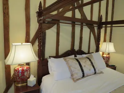 a bedroom with a bed with white sheets and two lamps at The Greyhound - Historic former Inn in Glemsford