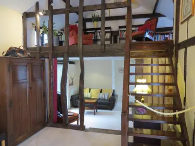 a room with a loft bed with a spiral staircase at The Greyhound - Historic former Inn in Glemsford