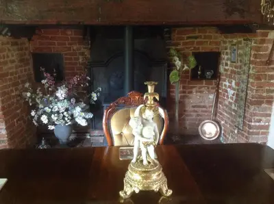 a statue on a table in a room with a fireplace at The Greyhound - Historic former Inn in Glemsford