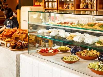 a display case filled with lots of different types of food at ibis Cambridge Central Station in Cambridge