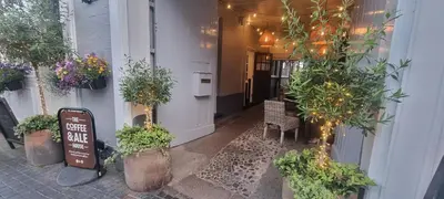 a sign in front of a building with potted plants at White Horse in Maldon