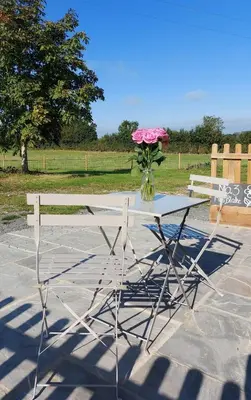 a table with a vase of flowers on top of it at Great Sampford B&B Sorrells farm in Hempstead