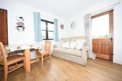 a living room with a couch and a table at Great Sampford B&B Sorrells farm in Hempstead
