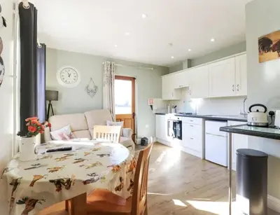 a kitchen and living room with a table and a table and chairs at Great Sampford B&B Sorrells farm in Hempstead