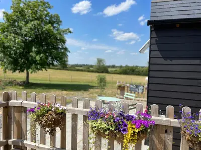 a wooden fence with flower boxes on it at Great Sampford B&B Sorrells farm in Hempstead