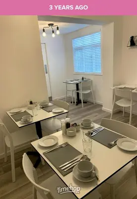 a dining room with white tables and chairs at Alder Lodge in Cambridge