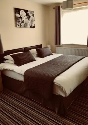 a large bed in a bedroom with a window at Alder Lodge in Cambridge