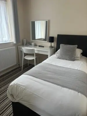 a bedroom with a white bed and a desk at Alder Lodge in Cambridge