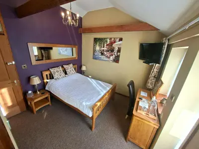 a small bedroom with a bed and a tv at Old Field Barn Luxury B&B in Attleborough