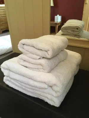 a pile of white towels sitting on top of a table at Old Field Barn Luxury B&B in Attleborough