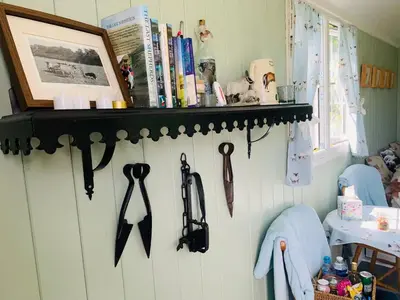 a rack with umbrellas hanging on a wall at Bells Meadow Shepherds Hut in Kings Lynn