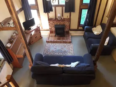 a living room with a blue couch and a fireplace at Granary Cottage in Hardwick
