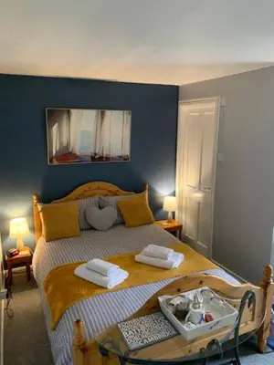 a bedroom with a bed with two towels on it at The Holly Tree in Cambridge