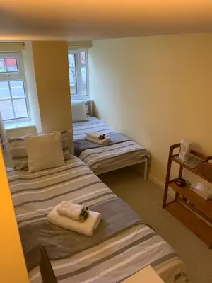 a room with two beds with towels on them at The Holly Tree in Cambridge