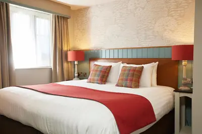 a bedroom with a large bed with a red blanket at Feathers by Chef & Brewer Collection in Wadesmill