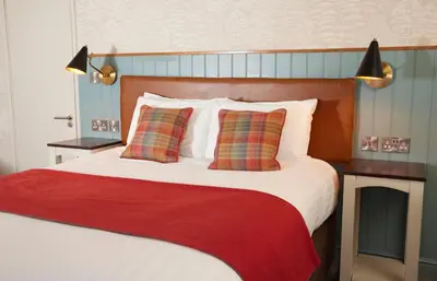 a bed with a red blanket and two pillows at Feathers by Chef & Brewer Collection in Wadesmill