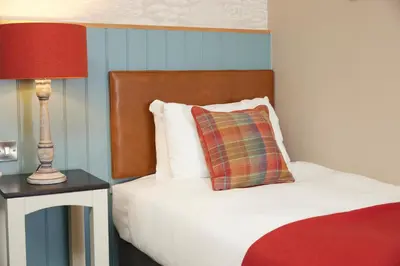 a bedroom with a bed with a pillow and a lamp at Feathers by Chef & Brewer Collection in Wadesmill