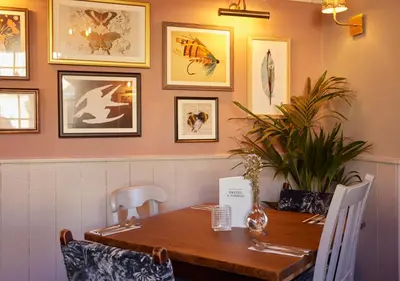 a dining room with a wooden table and chairs at Feathers by Chef & Brewer Collection in Wadesmill