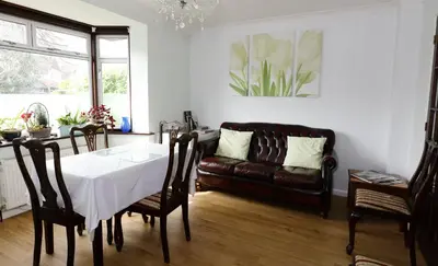 a living room with a table and a couch at Aylesbray Lodge in Cambridge