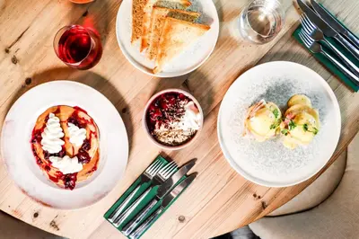 a wooden table with three plates of food on it at All Saints Resort in Bury Saint Edmunds