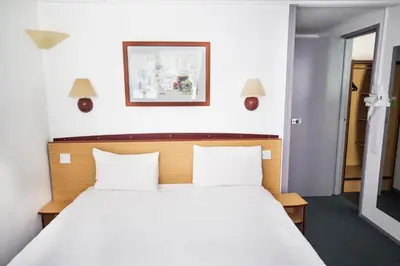 a bedroom with a large white bed with two pillows at Campanile Hotel - Basildon - East of London in Basildon