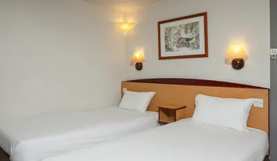 two beds in a hotel room with white sheets at Campanile Hotel - Basildon - East of London in Basildon