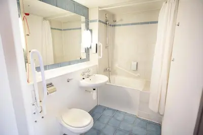 a bathroom with a toilet and a sink and a tub at Campanile Hotel - Basildon - East of London in Basildon