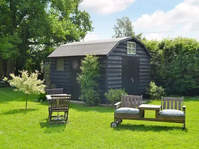 two chairs and a table in front of a cabin at Hillcroft in Cold Norton