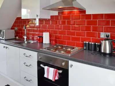 a kitchen with a stove and a red brick wall at Hillcroft in Cold Norton