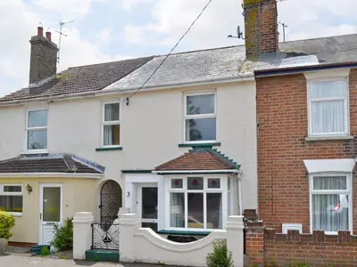 a white house with a red brick at Sea Folly in Brightlingsea