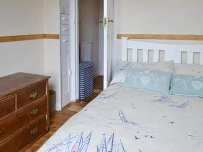 a bedroom with a bed and a dresser at Sea Folly in Brightlingsea