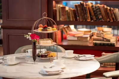 a table with a plate of pastries and coffee cups at Clayton Hotel Cambridge in Cambridge