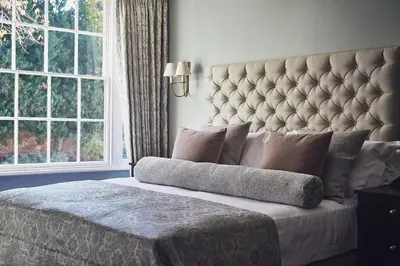 a bedroom with a large bed with a large headboard at Marquis Suffolk in Ipswich